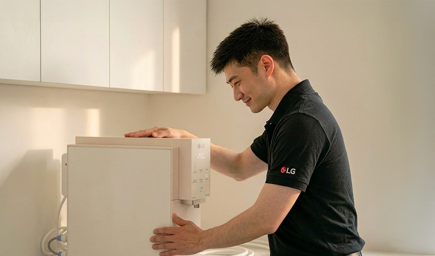 LG professional installing a water purifier in a kitchen